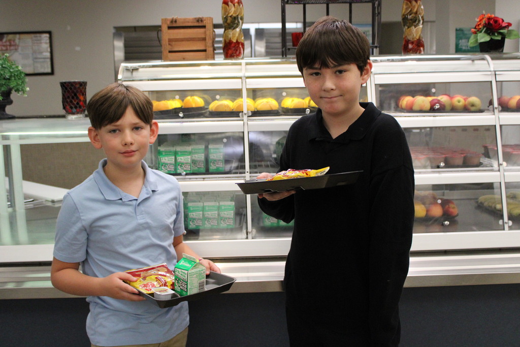 2 male students with trays of food