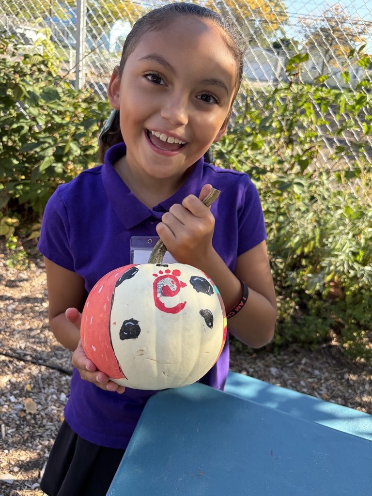 Student smiling with their painted pumpkin.