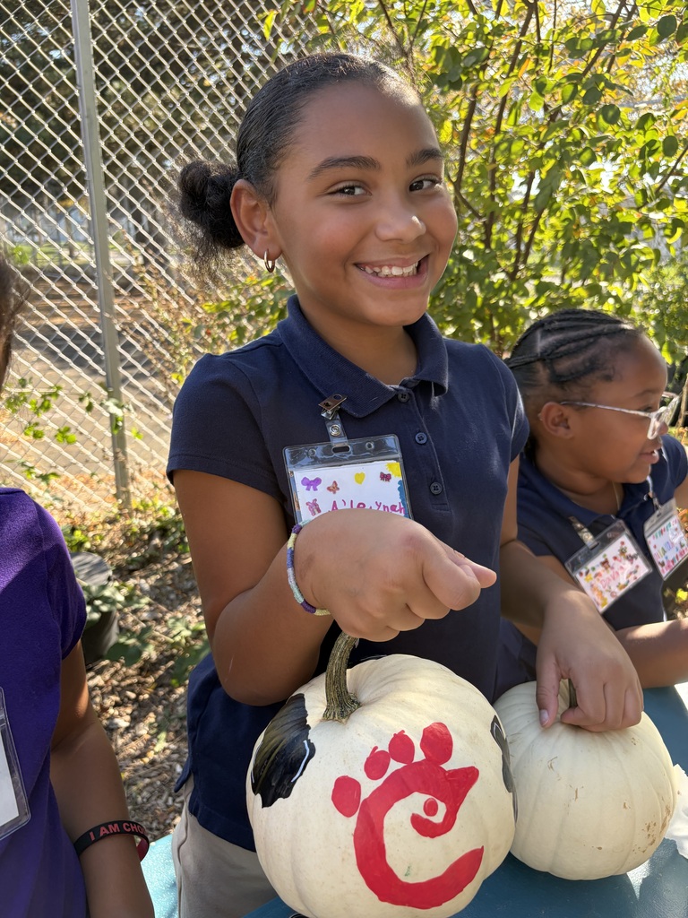 Student smiling with their painted pumpkin.
