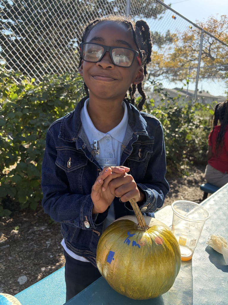 Student smiling with their painted pumpkin.