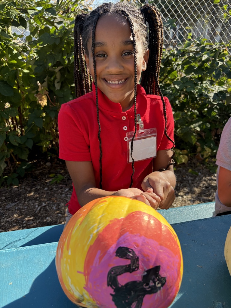 Student smiling with their painted pumpkin.
