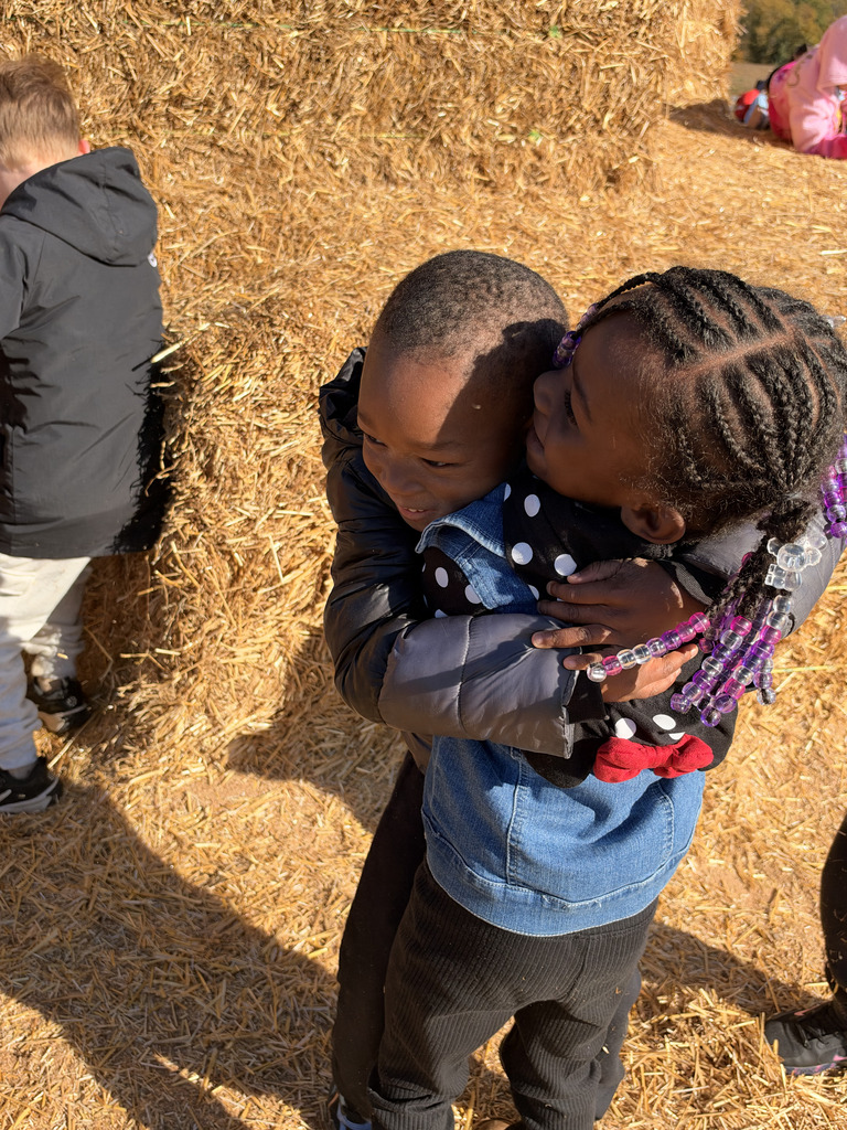 Students hugging on the giant hay pile