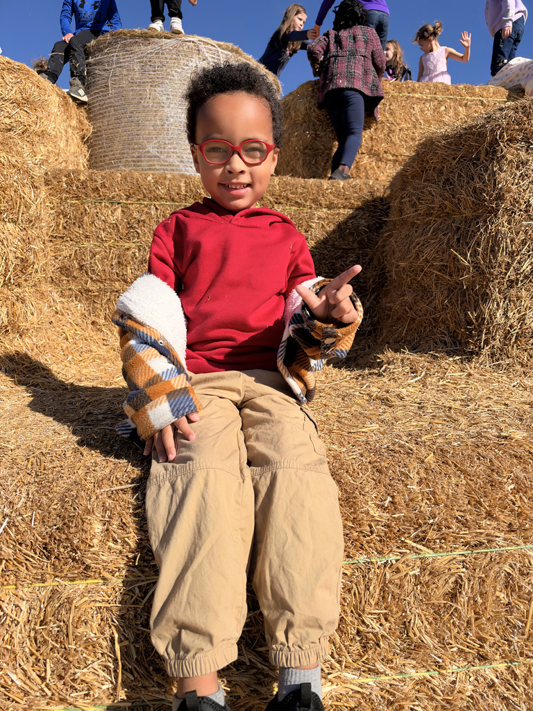 Student sitting on the giant hay pile