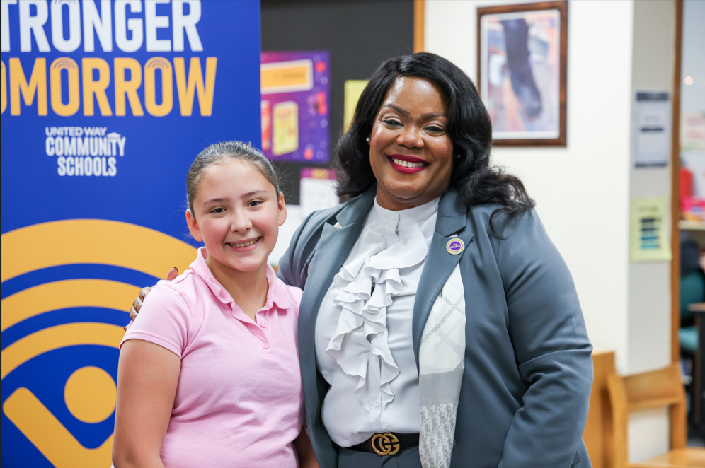 Superintend/ CEO Dr. Natalyn Gibbs smiling next to a student in a pink collared shirt.