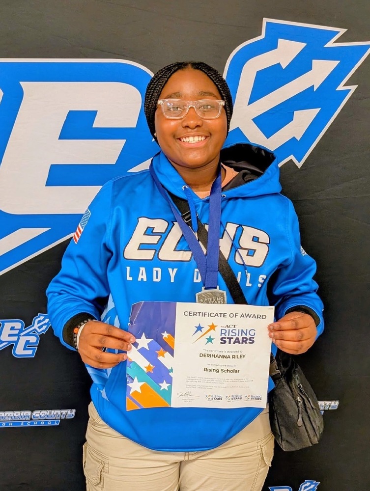 Student holding recognition certificate