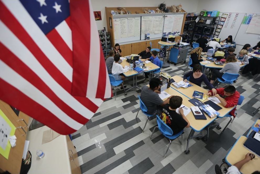 Students sit under the US Flag
