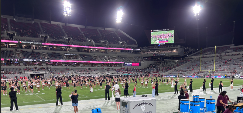 Felicita cheer students perform with San Diego State University cheerleaders on the field during the Aztec game.