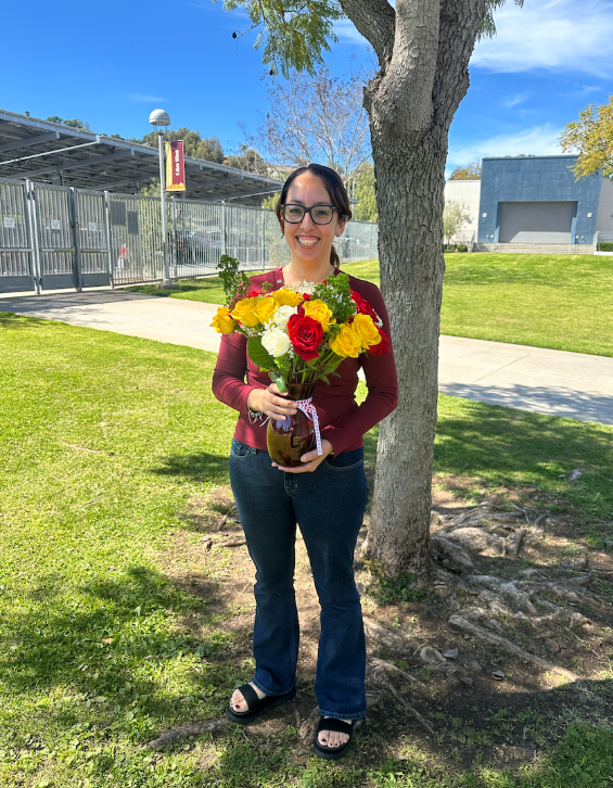 Ms. Wendy hold flowers outside of Bernardo School