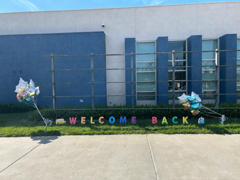 Balloons and letters spelling "Welcome Back" in the grass outside Farr Elementary School.