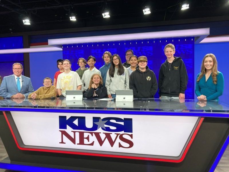 Bear Valley Middle School TV Team students sit at the KUSI News anchor desk.