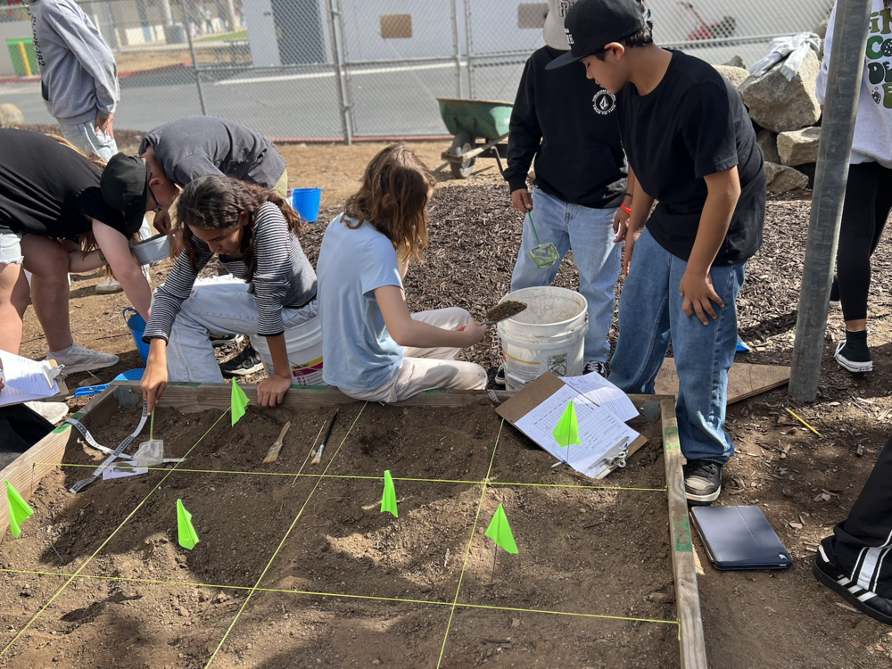6th grade students digging up artifacts to learn about culture and eras.