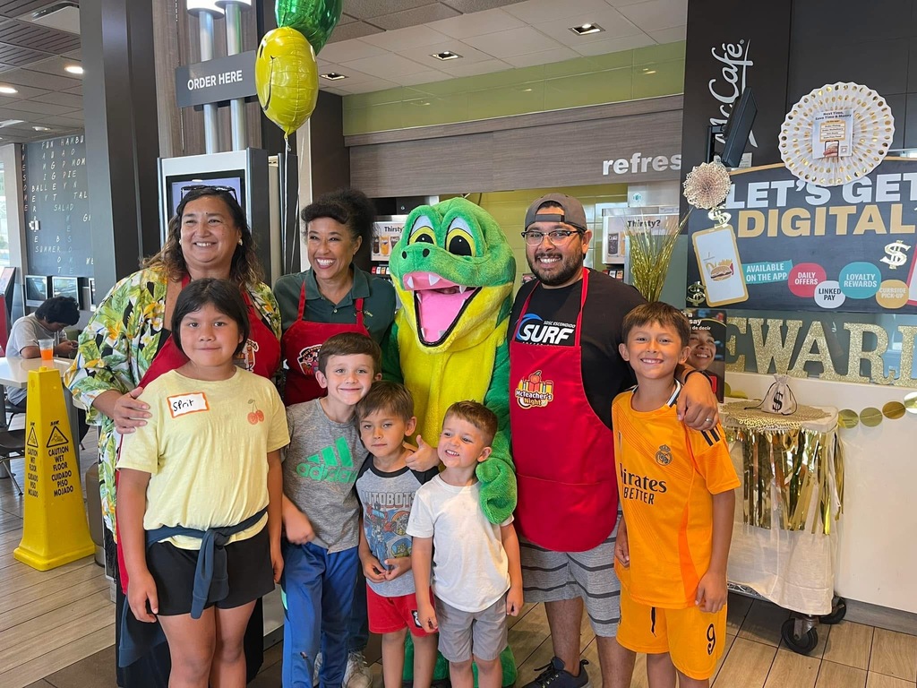 Teachers with students and Gator