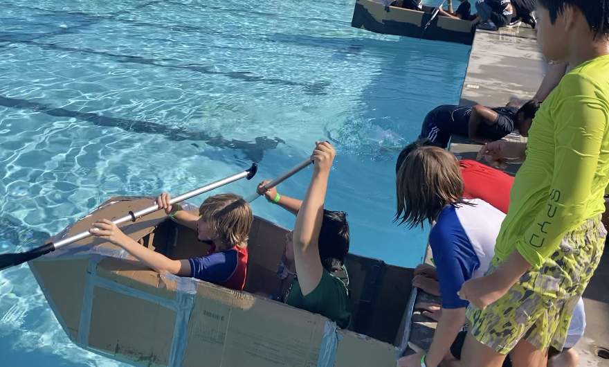 Two students about to start rowing their boat during the Boat Challenge.