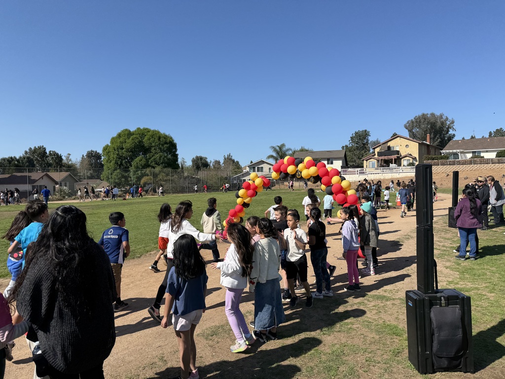 children running through a balloon arch