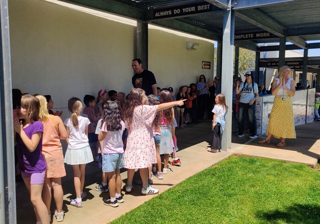 Mr. Lyche being clapped out by 1st grade students down the hallway