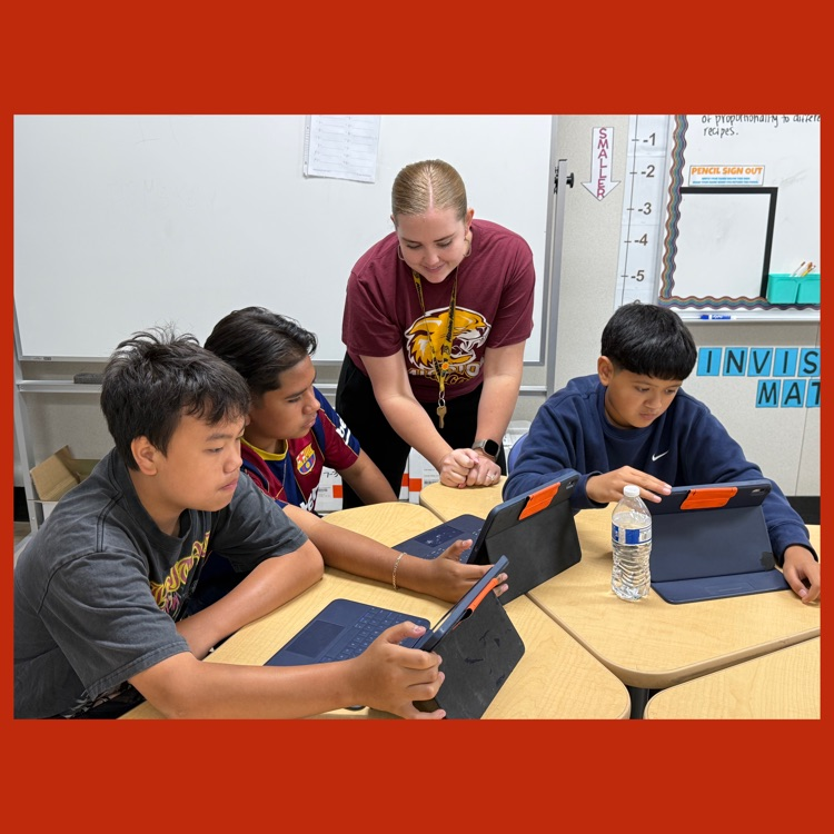 A photo of Ms. Kelly helping a group of students scale recipes in the "Recipe Challenge"