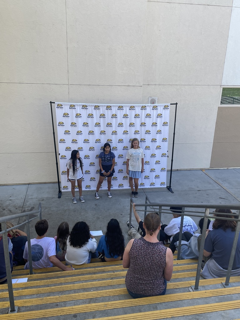 Three students performing a skit in front of peers
