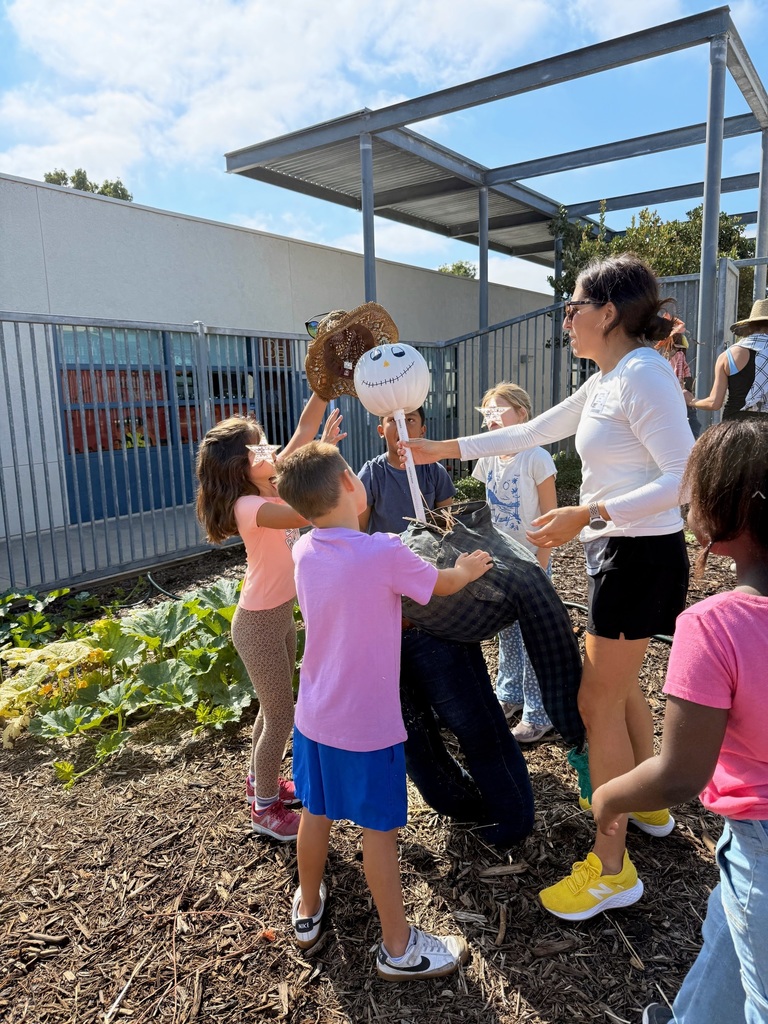 Parent & students putting a scarecrow together