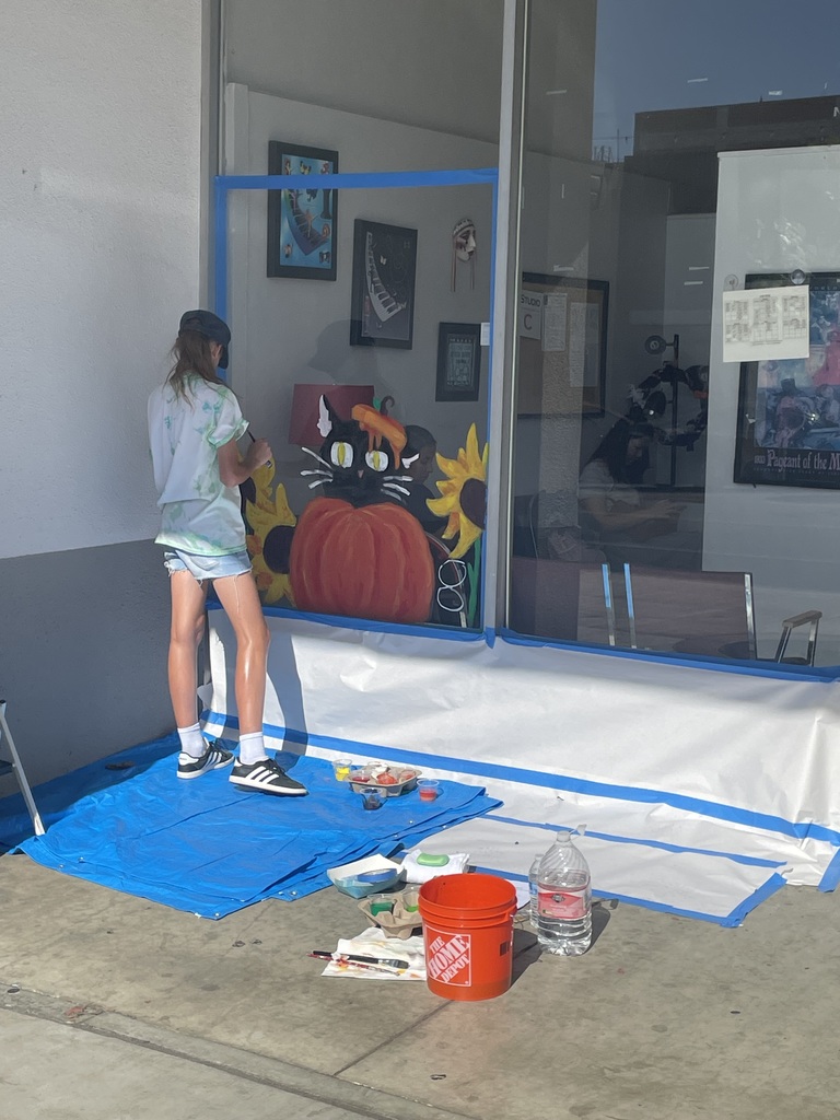 Student painting on window