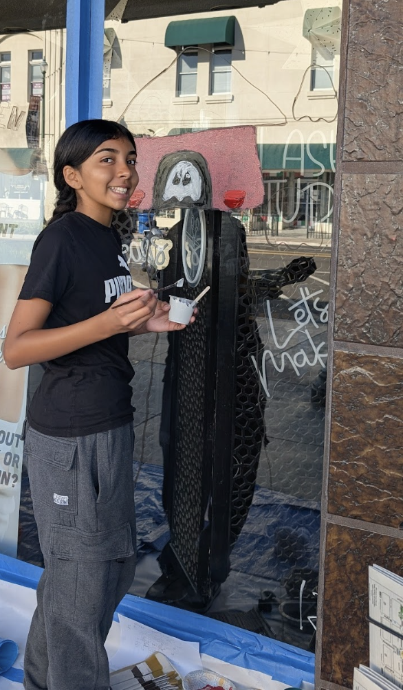 Aubrey Hernandez with her Tower Halloween window painting.