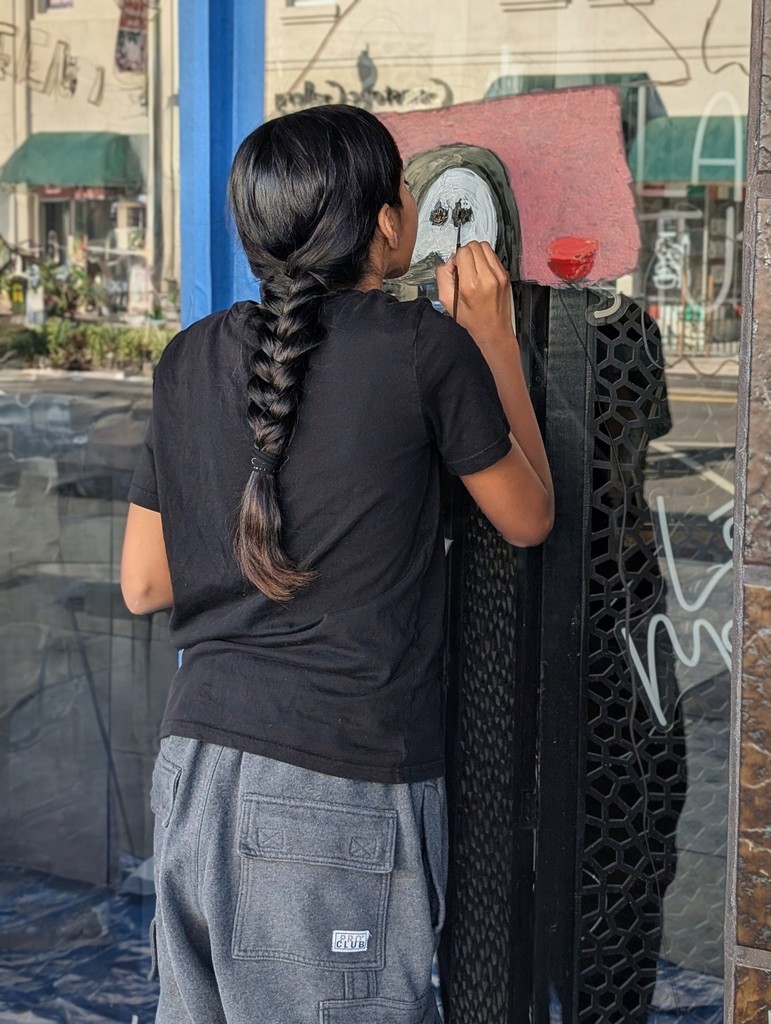 Aubrey Hernandez  working on her Tower Halloween window painting.