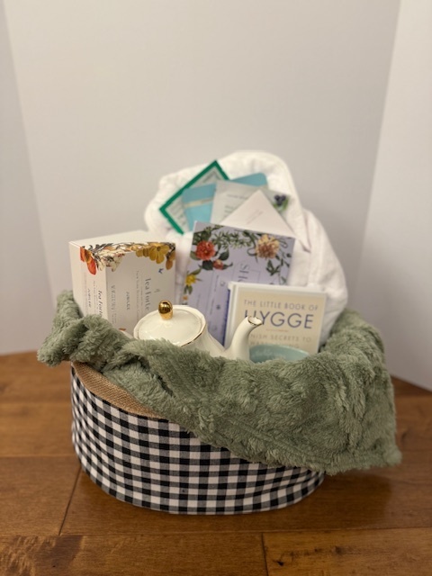 Basket with a tea kettle and various tea time items