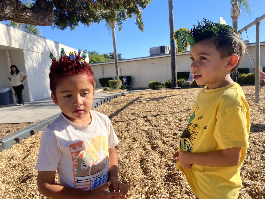 two students outside one is wearing yellow and other is wearing white