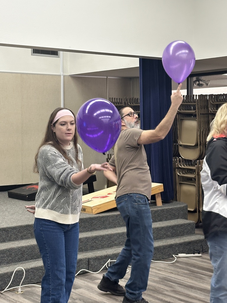 Teachers playing keep the balloon in the air with one hand
