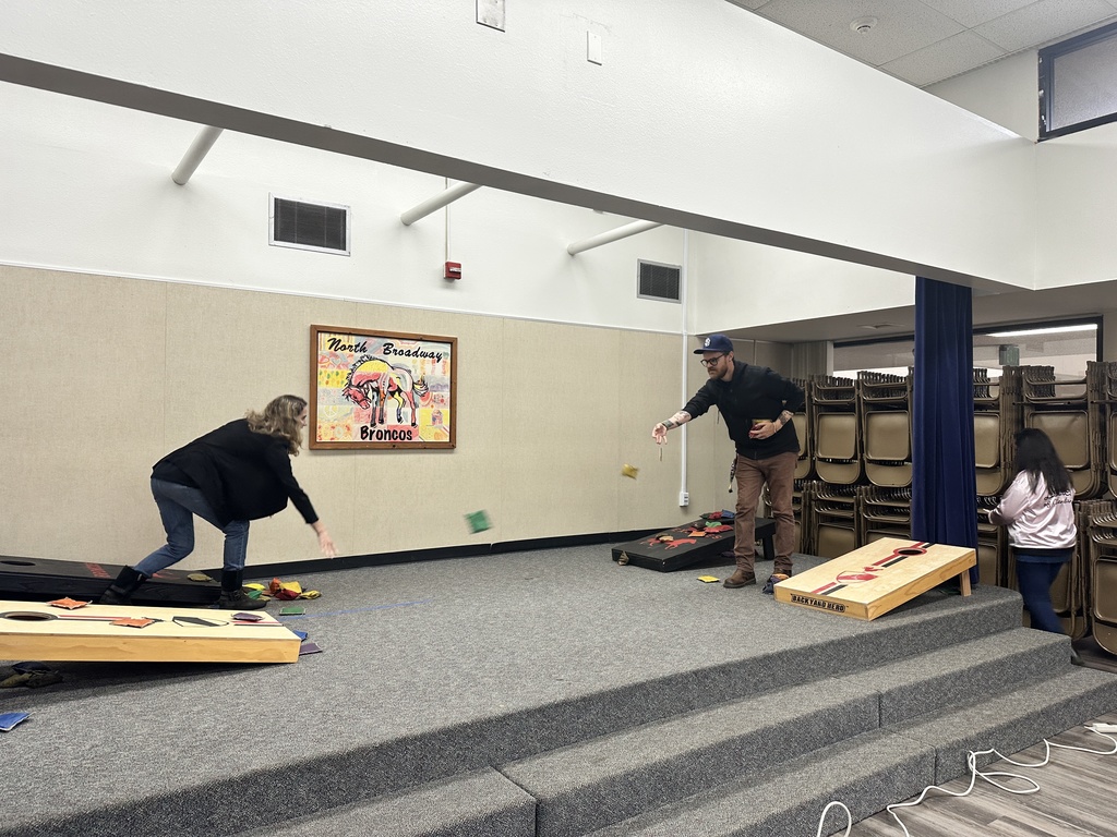 2 teachers playing cornhole