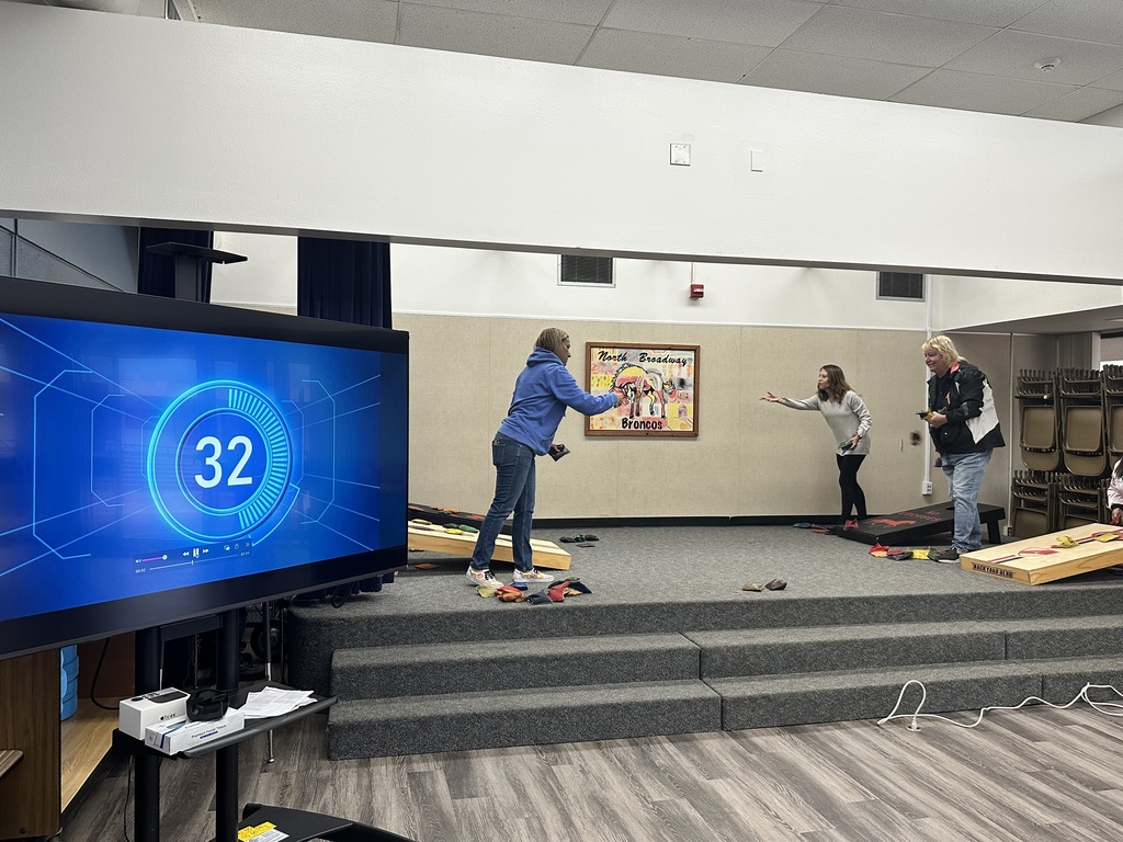 3 teachers playing cornhole