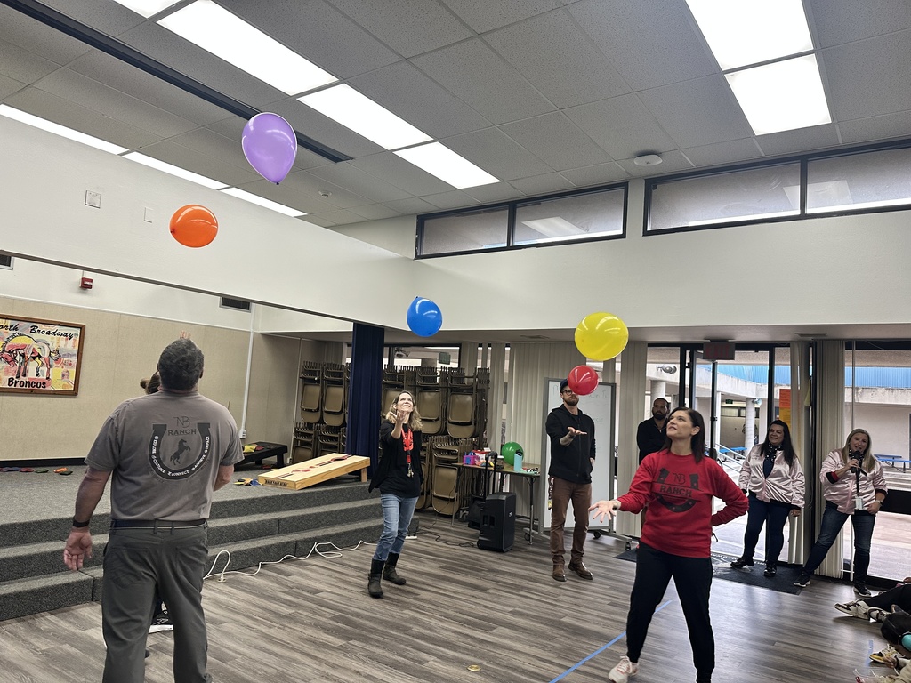 Teachers playing keep the balloon in the air with one hand