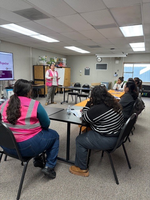 Universidad Popular community educator, Vanessa Sifuentes, speaks to parents sitting down about different types of natural disasters that can occur in the state of California