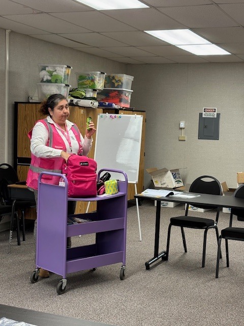 Community educator Vanessa Sifuentes shows and explains to parents the different items that are inside disaster preparedness backpacks such as toilet paper, water, and non perishabe food