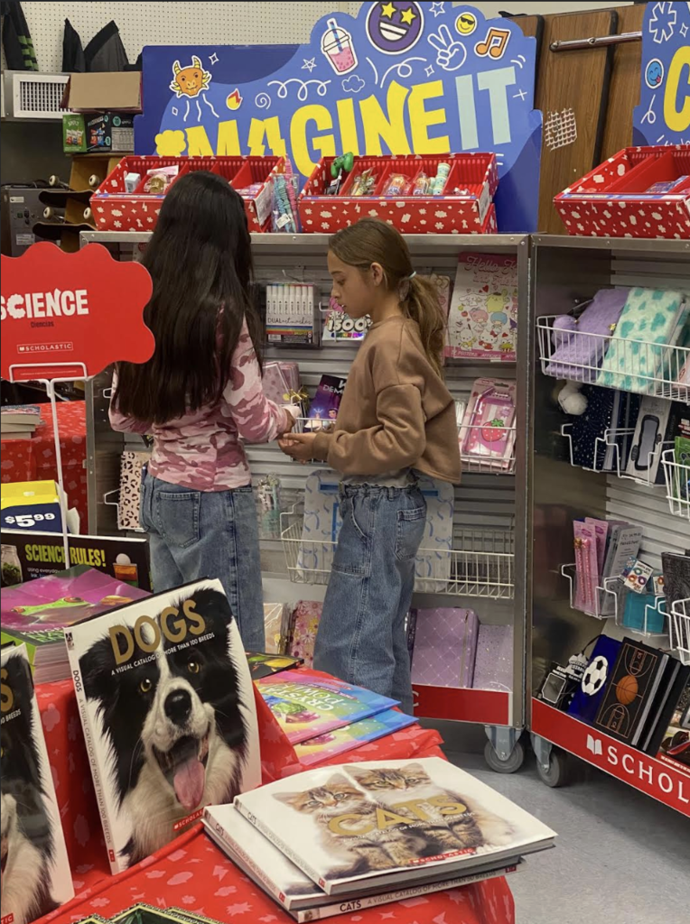 Two Dragon students checking out items at the Book Fair