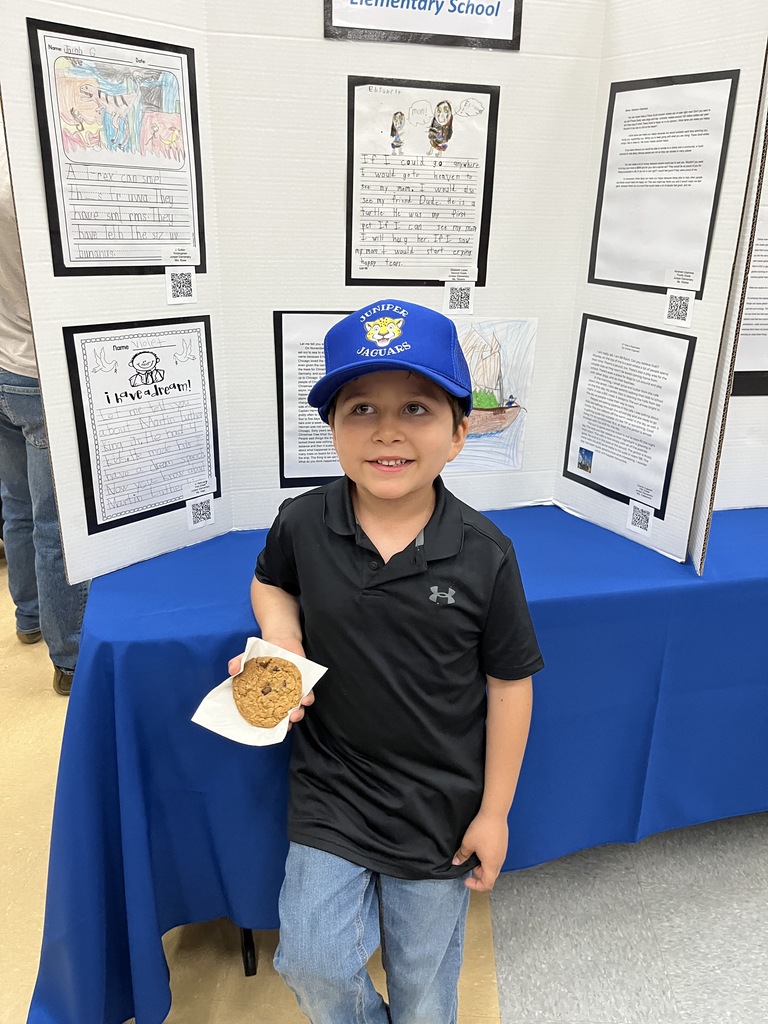 Student posing with their writing in the background