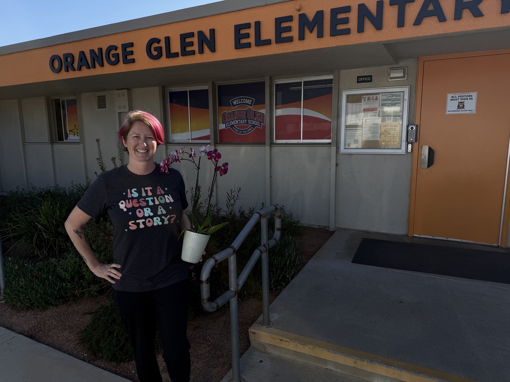 Ms.Bannister standing outside the office holding flowers