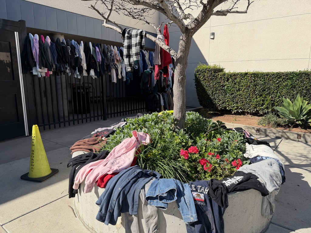 Piles of sweaters hanging from gate