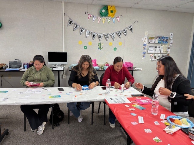 Four moms sit in a table while decoating their self care goodie bags 