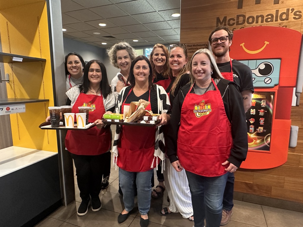 a group of teachers and staff serving food at McDonald's