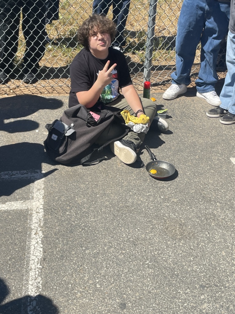 Student cooking an egg on the blacktop