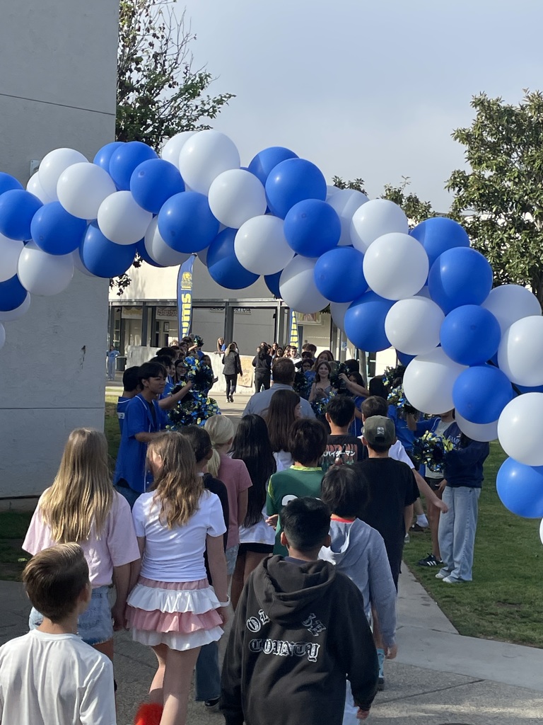 Students walking through a ballon arch