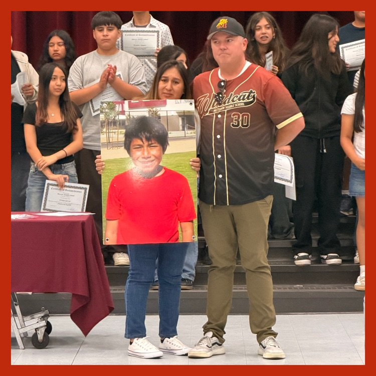 Aiden's mom holding his portrait with our Principal, Jason Hoff