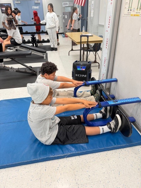 Student working out in the weight room with music.