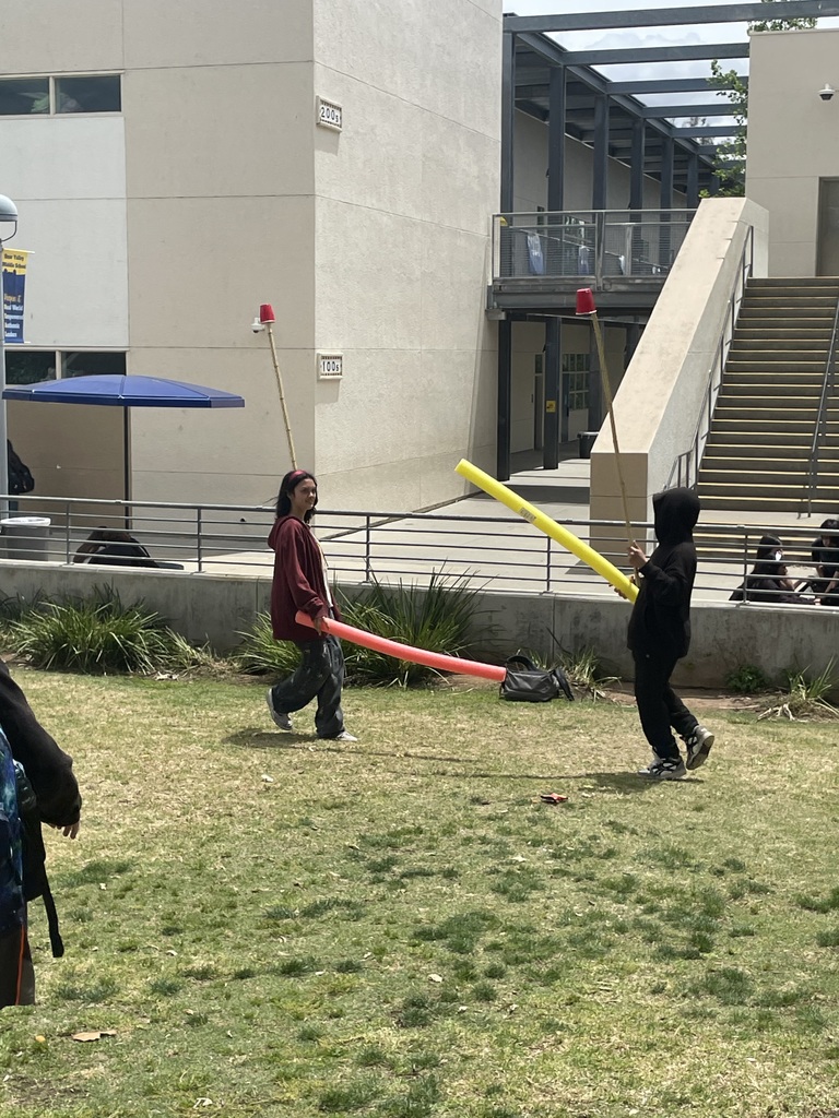 Two students with foam noodles