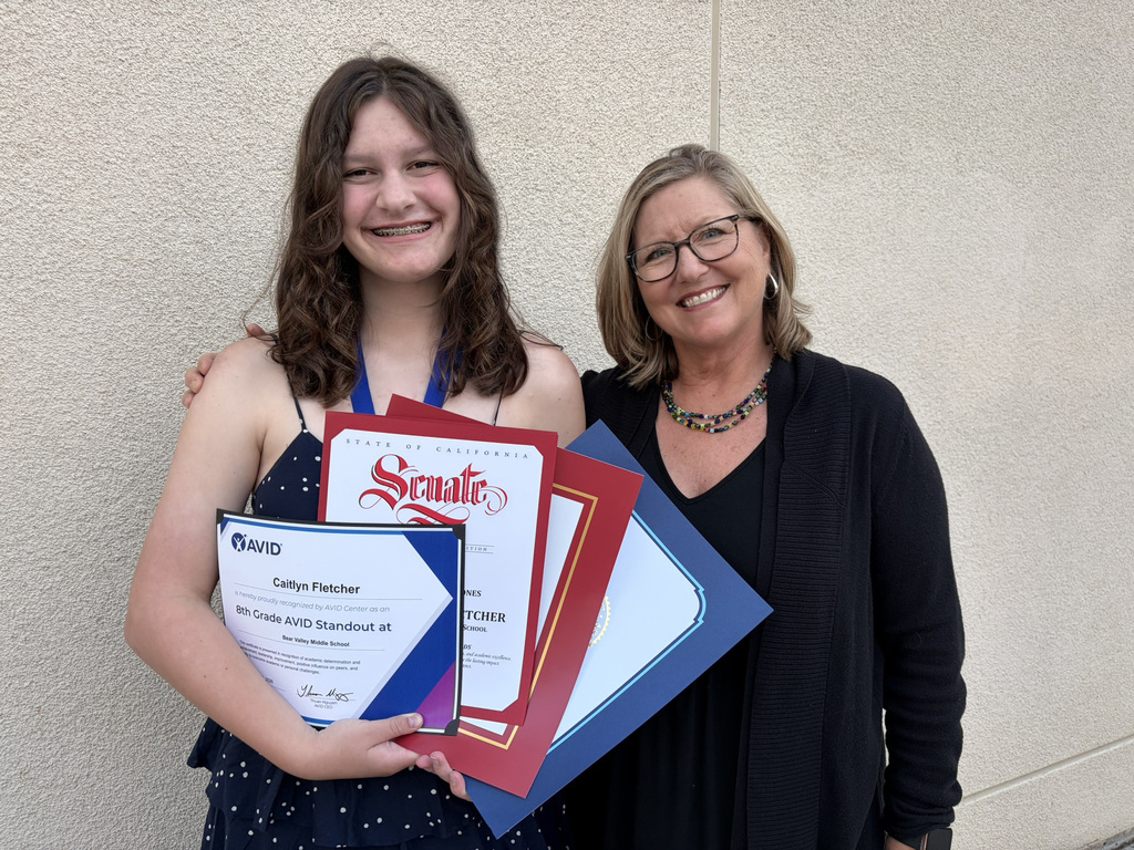 student and teacher with award