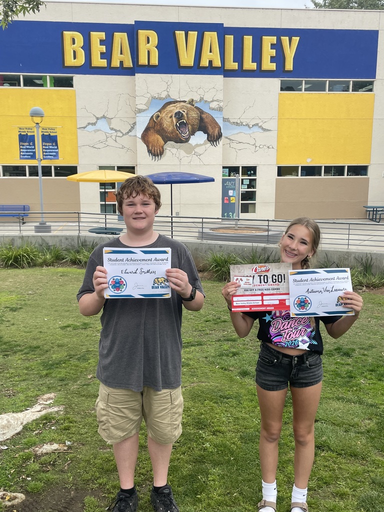 two students holding awards
