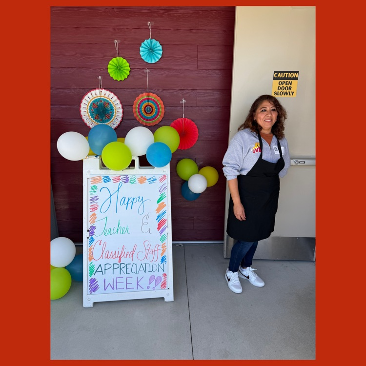 A Mission parent standing next to a sign saying "Happy Teacher and Classified Staff Appreciation Week!" greeting teachers and staff at the door to the lounge for lunch