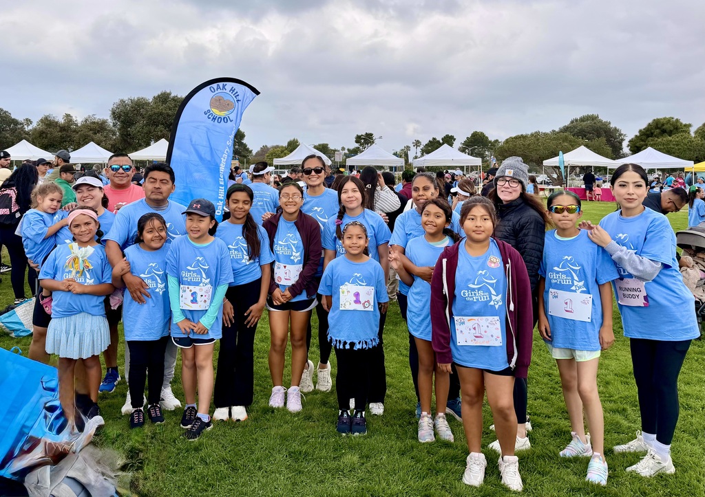 Girls on the Run team smiling proudly together after completing their 5K race, celebrating teamwork, confidence, and accomplishment.
