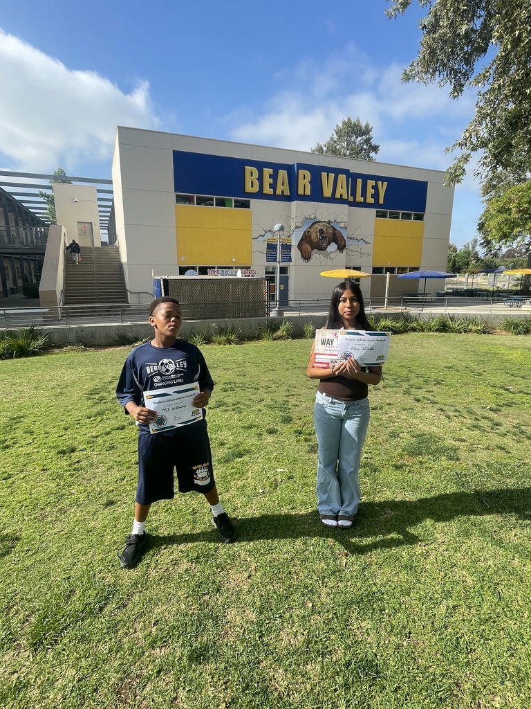 Two students standing with their awards