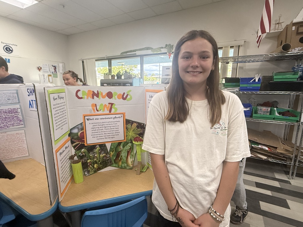 student posing with plant project